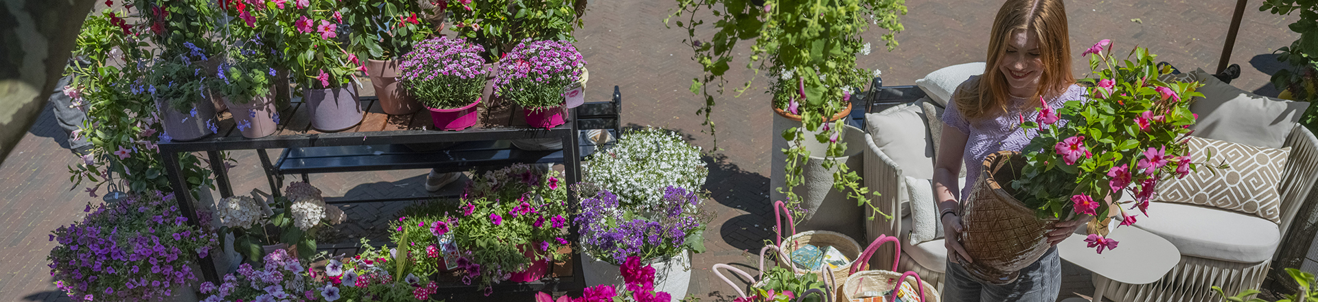 student met bloemenpot in haar handen in een bloemenwinkel.