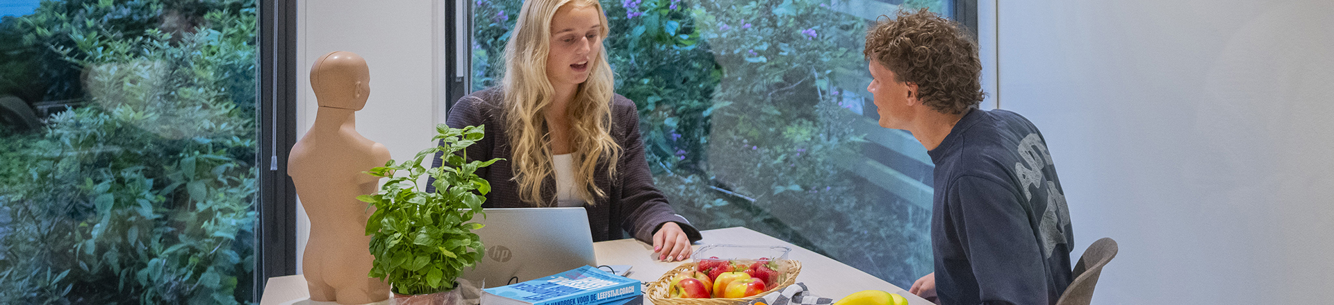 student geeft voedingsadvies aan andere student.