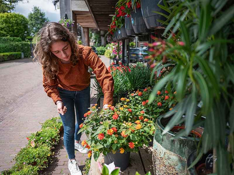 Student Aeres MBO Heerenveen bij bloemenwinkel buiten
