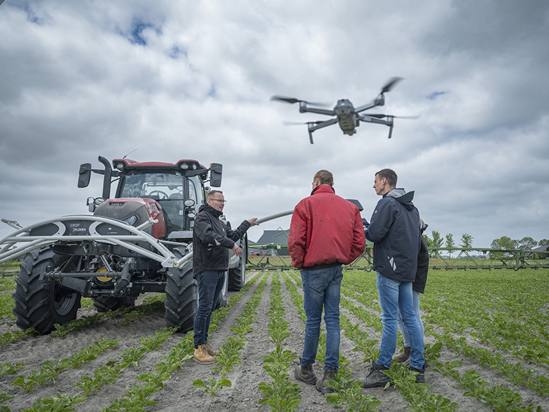 jongens met drone bij trekker